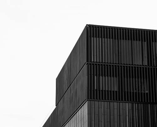 office building low-angle grayscale photography of a high-rise building gate